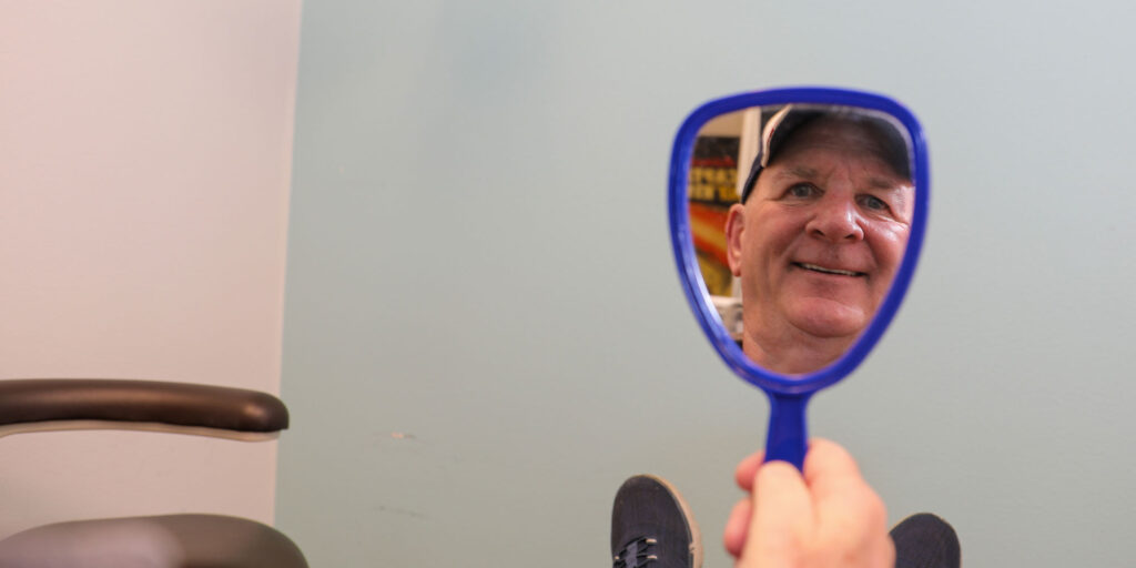 dental patient smiling in mirror